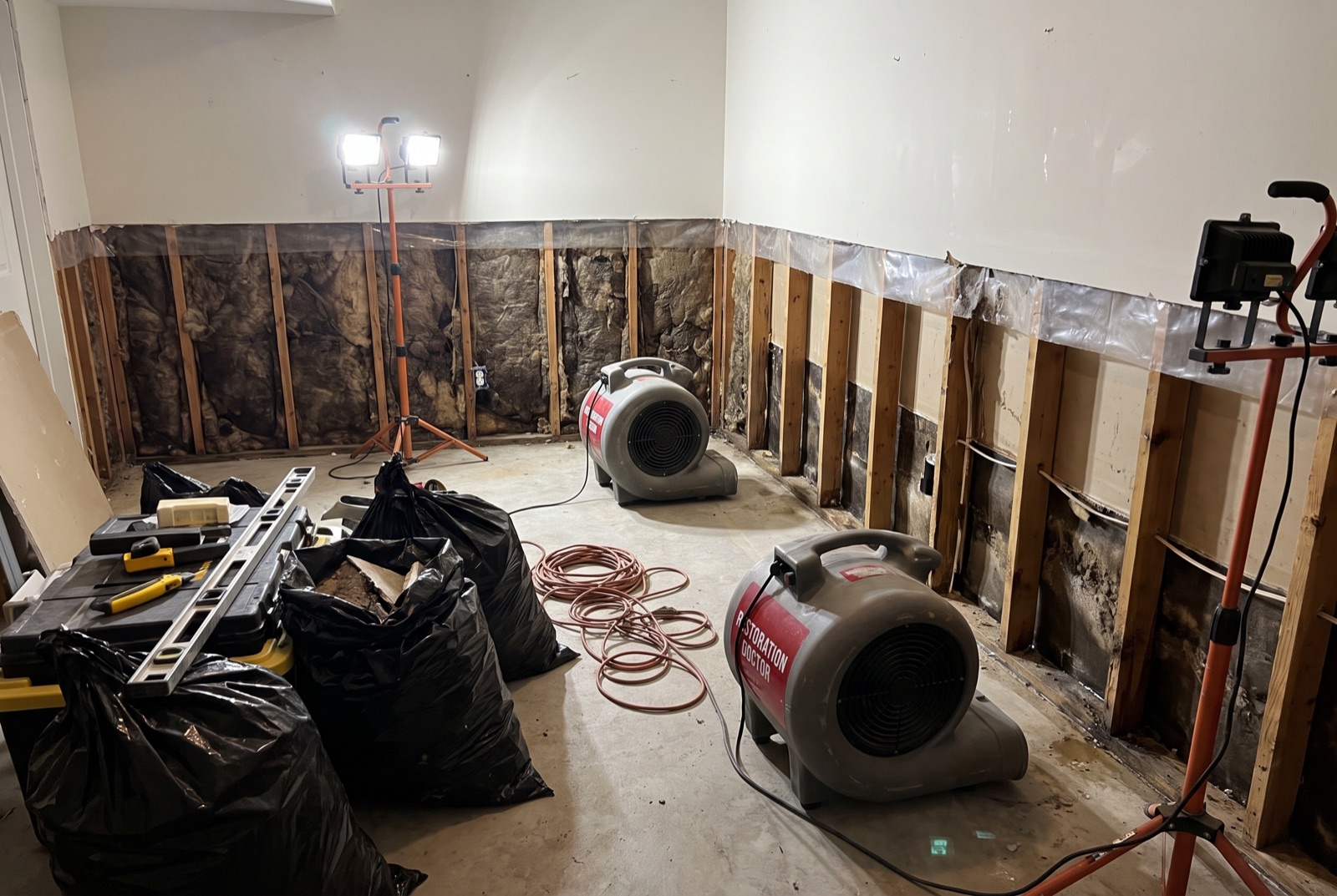 Flood cuts with exposed studs drying under air movers — illustrating: is a water damaged ceiling dangerous