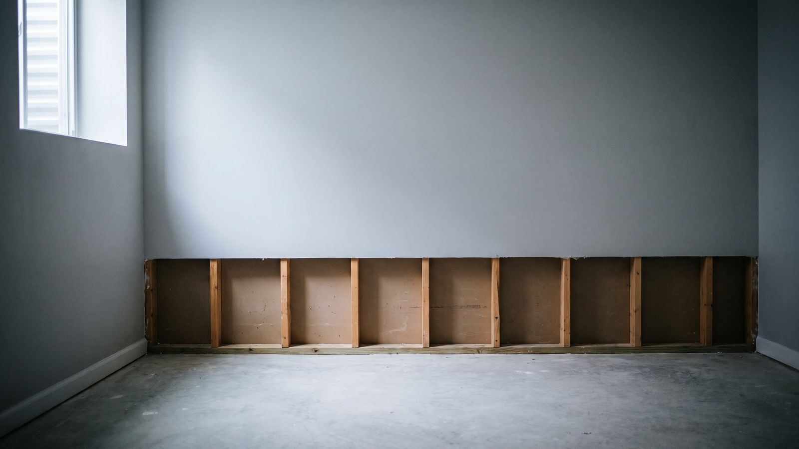 Two-foot flood cut across a finished basement wall Flood cut drywall removed in a straight line two feet above a basement slab, with empty stud bays open below