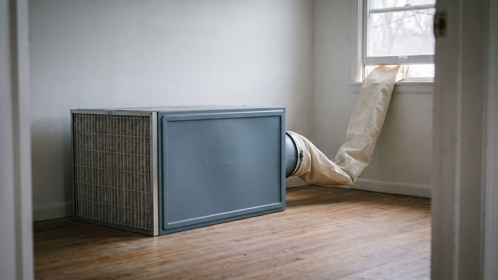 Air scrubber ducted out a window during deodorization Air scrubber with a pleated filter face and a lay-flat duct venting out a window during deodorization