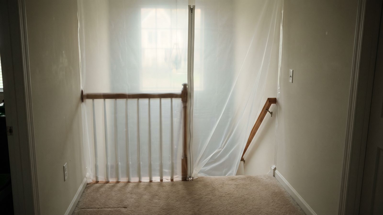Zippered containment sheeting at a basement stairwell Plastic sheeting with a zipper door sealing a basement stairwell for sewage backup cleanup containment