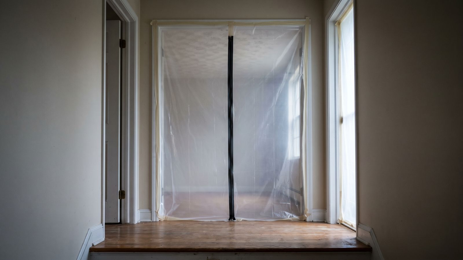 Sealed plastic containment with a zippered entry Plastic sheeting with a zippered entry sealed over an interior opening before water damage popcorn ceiling asbestos work