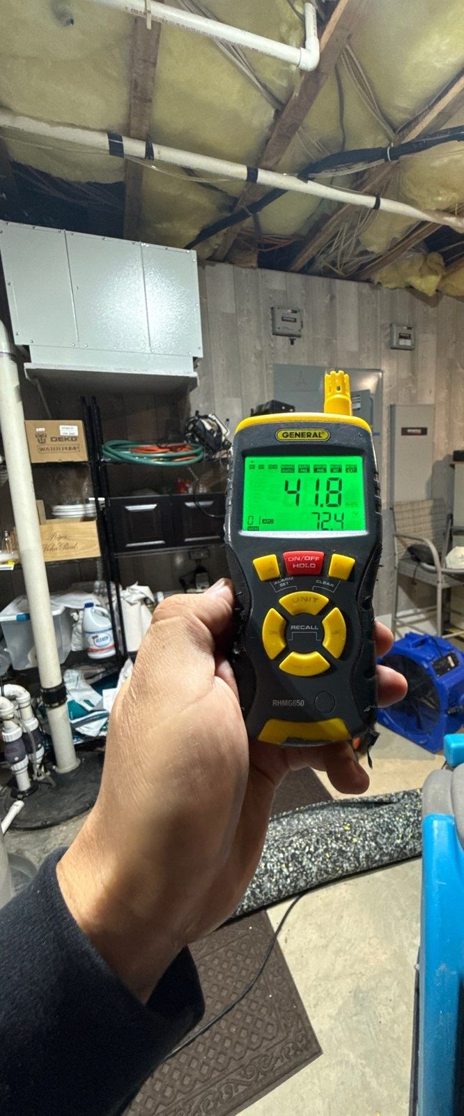 Handheld meter reading 41.8 percent relative humidity in a basement mechanical room with an air mover and a dehumidifier, McLean, VA, October 28, 2025