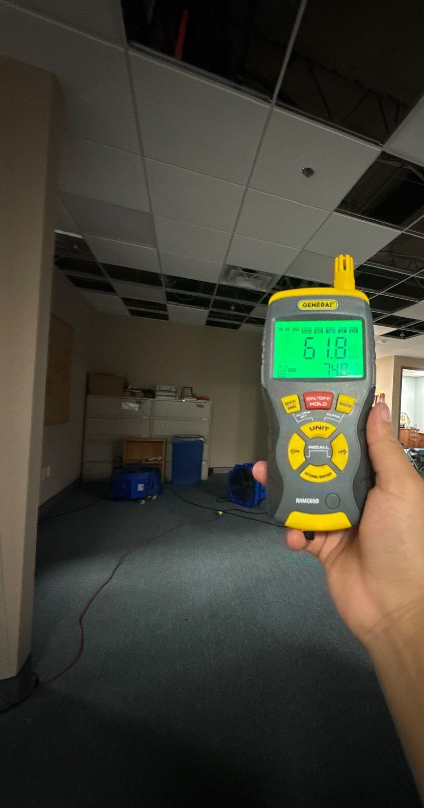 Handheld meter reading 61.8 percent relative humidity in an office suite with ceiling tiles removed, Sterling, VA, September 19, 2025