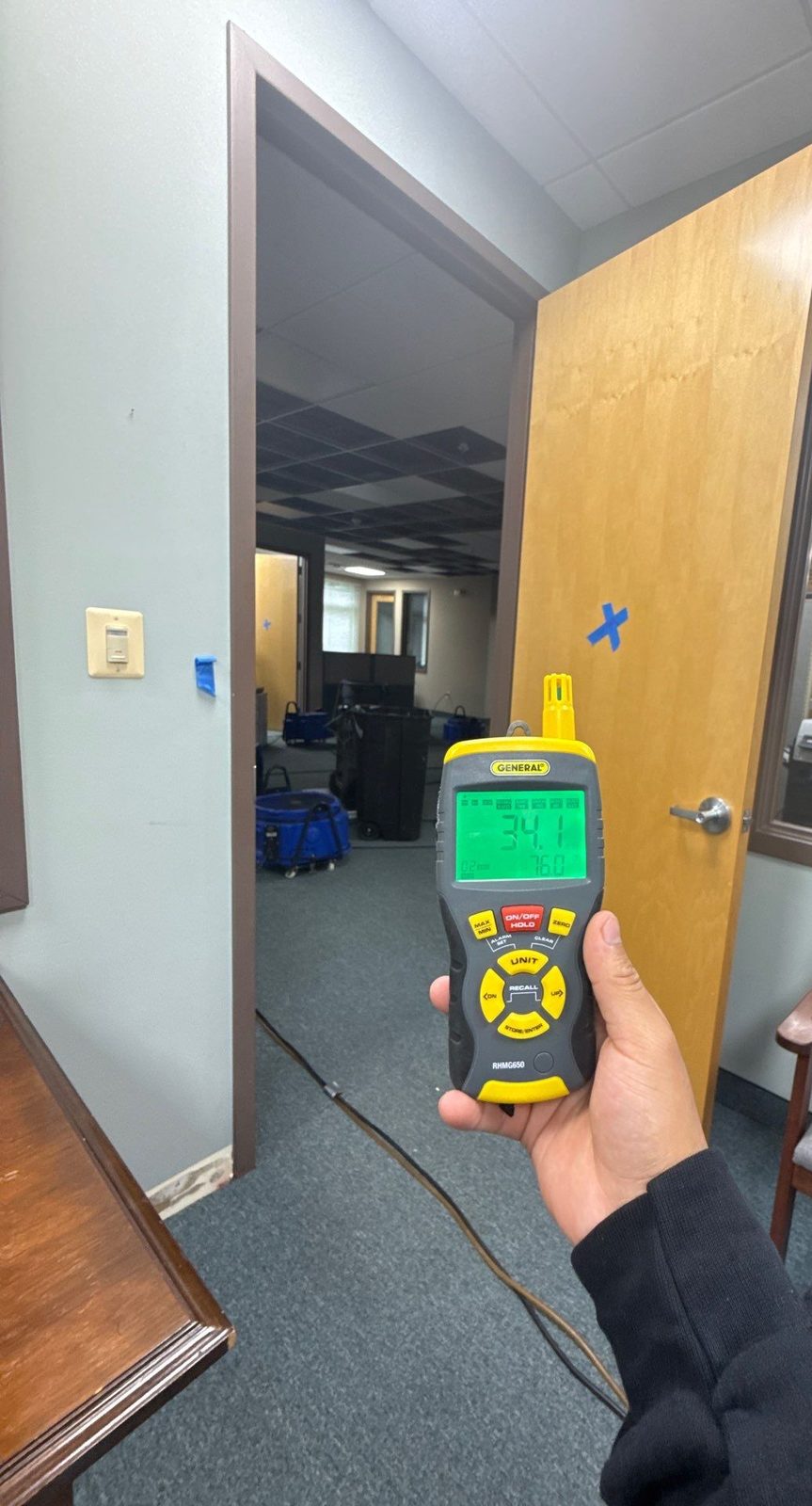 Handheld meter reading 34.1 percent relative humidity held beside an open door in an office suite, Sterling, VA, September 22, 2025