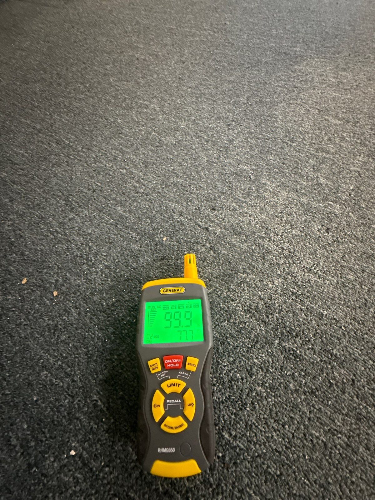 Moisture meter lying on carpet with its display at the top of its scale, Sterling, VA, September 19, 2025